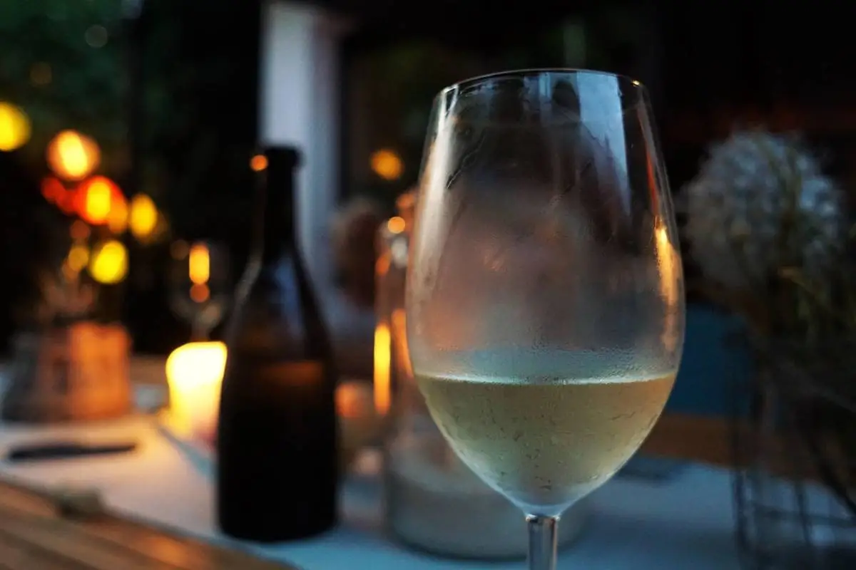 Calice di vino bianco dell’Oltrepò Pavese in un’atmosfera serale rilassante