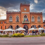Municipio di Rivanazzano Terme in mattoni rossi con torre dell’orologio e gazebo bianchi in piazza, Oltrepò Pavese