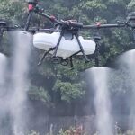Droni in agricoltura: drone agricolo con serbatoio e quattro ugelli che nebulizza un trattamento di precisione sulle colture