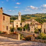 Veduta dei borghi storici della Valle Versa in Oltrepò Pavese, tra chiese, case in pietra e colline ricoperte di vigneti.